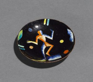 Small black dish decorated with an abstract dancing figure and colorful geometric forms.
