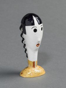 An abstract metal head of a woman painted in black and white with an orange collar.