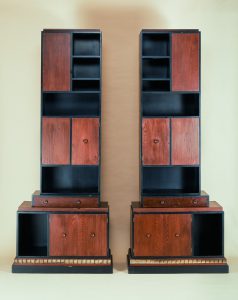 Two bookcases in brown and black wood composed of rectangles of different sizes.