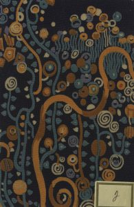 Square of dark blue fabric with a dense pattern of curving lines and loose spirals in hues of dark orange, white, and teal