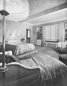 Black and white photo from 1933 of a bedroom with a trumpet-shaped pendant lamp hanging over one of the beds. The lamp’s design is similar to the pendant lamps in the Wormser bedroom.