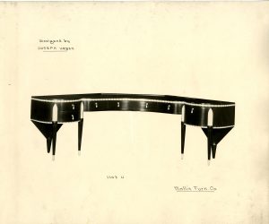 Black and white image of a shiny, curved black desk with white detailing. The words “Designed by Joseph Urban” are written in the upper left corner. In the lower right corner, “Mallin Furn. Co.” is written.