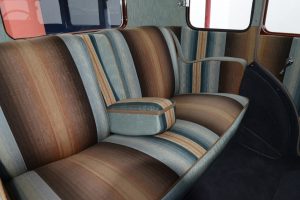 Color photo of an automobile interior with vertically striped upholstery in alternating ombré shades of blue and brown.