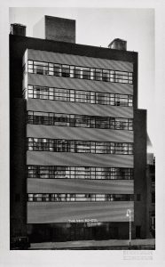 Building façade divided into alternating horizontal bands of glass windows and black and white glazed brick.