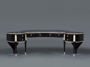 Shiny black dressing table with dramatic curves and ivory-colored detailing.