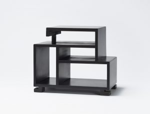 Black table composed of open rectangular forms stacked atop one another.